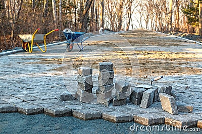 Construction site and paving on a walking path in a public park. Scene of preparatory work with carts for transportation of soil Stock Photo