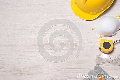 Construction site safety. Protective hard hat, gloves, glasses and masks on wooden background, Stock Photo