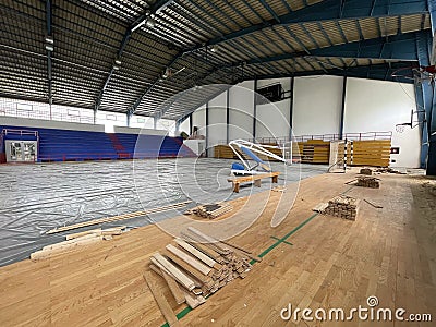 Construction site of sports hall, basketball court renovation, school gym indoor changing hardwood parquet flor and Stock Photo