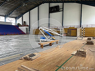 Construction site of sports hall, basketball court renovation, school gym indoor changing hardwood parquet flor and Stock Photo