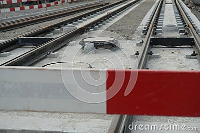 Construction site of a street-car line, embedding of metal rails in a concrete base with a barrier planks in the foreground . Stock Photo