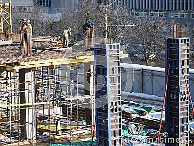 construction site in winter during the day. workers in uniform prepare the scaffolding urban development. belarus minsk 2021 Editorial Stock Photo