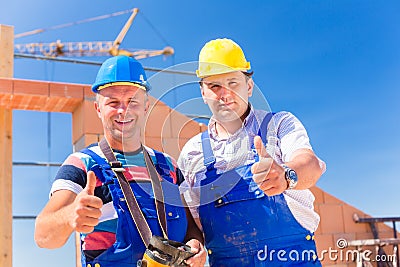 Construction site workers building walls on house Stock Photo