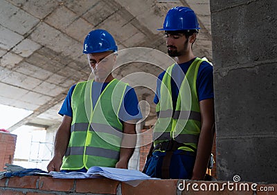 A construction site workers looking at the blue prints picture Stock Photo