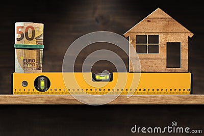 Construction Spirit Level with Roll of Euro Banknotes and a Model House Stock Photo