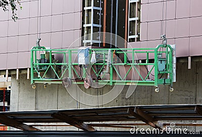 Construction suspended cradle without workers on a newly built high-rise building Stock Photo