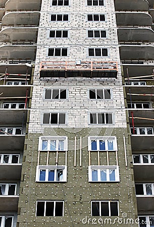 Construction suspended cradle without workers on a newly built high-rise building Stock Photo