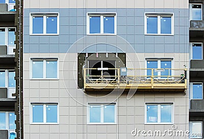 Construction suspended cradle without workers on a newly built high-rise building Stock Photo