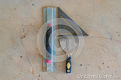 Construction tools background of palette knife, square and gauge on concrete Stock Photo