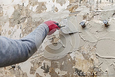 Construction worker applying plaster on the old bathroom wall Stock Photo