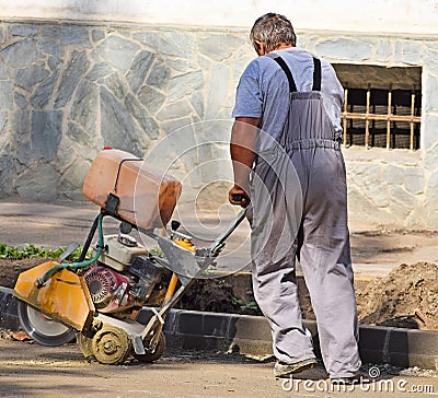 Construction worker with an asphalt sawing machinery Editorial Stock Photo