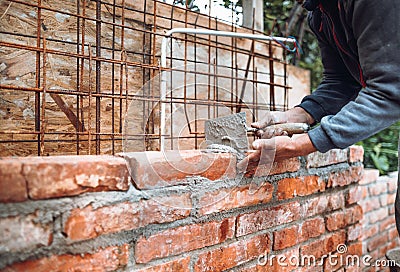 Construction bricklayer worker building brick walls with mortar, trowel. Industry details Stock Photo