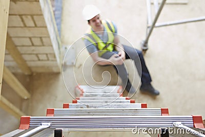 Construction Worker Falling Off Ladder And Injuring Leg Stock Photo