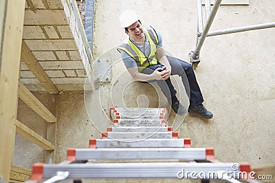 Construction Worker Falling Off Ladder And Injuring Leg Stock Photo