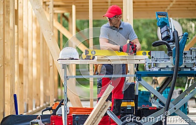 Construction Worker in Front of Newly Developed Wooden Made House Stock Photo