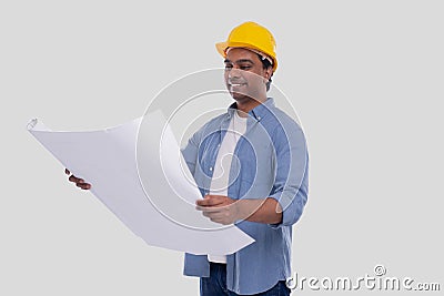 Construction Worker Holding House Plan in Hands Watching at it. Architect Holding Blueprints. Yellow Hard Helmet Stock Photo