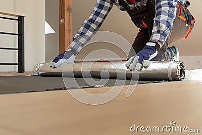 Construction worker installing laminate floor in a new renovated attic. Home improvement concept Stock Photo