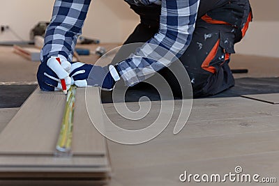 Construction worker installing laminate floor in a new renovated attic. Home improvement concept Stock Photo