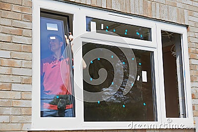 Construction Worker Installing New Windows In House Stock Photo