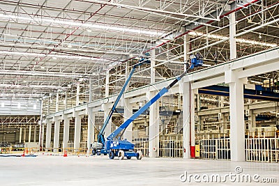 Construction worker is lifted by a boom lift Stock Photo