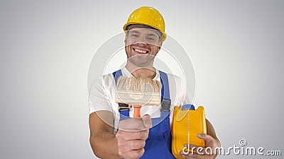 Construction worker painter showing paint brush to camera and sm Stock Photo