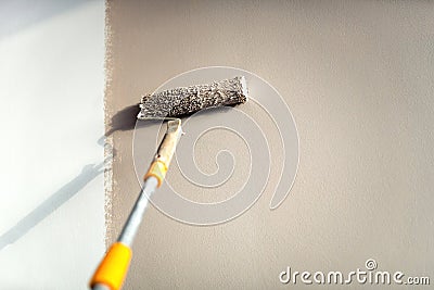 Construction worker painting walls using paint roller. Stock Photo