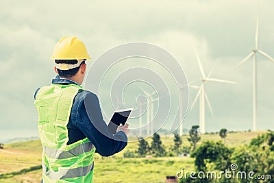 Construction Worker Planning Contractor Checking at wind turbine construction. A man hold tablet for working Stock Photo