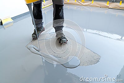Construction worker renovates balcony floor and pours watertight resin and glue before chipping and sealing Stock Photo