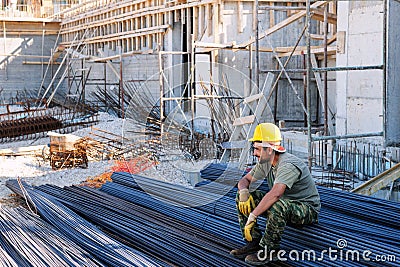 Construction worker resting on steel bars Stock Photo