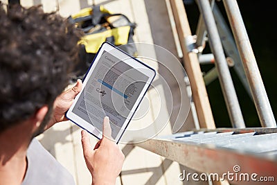 Construction Worker Signing Contract On Digital Tablet Stock Photo