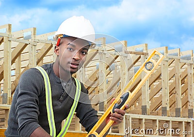 Construction worker on site holding level with white helmet Stock Photo