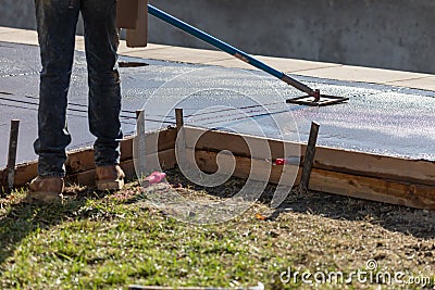 Construction Worker Smoothing Wet Cement With Long Handled Edger Tool Stock Photo