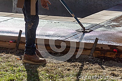 Construction Worker Smoothing Wet Cement With Long Handled Edger Tool Stock Photo