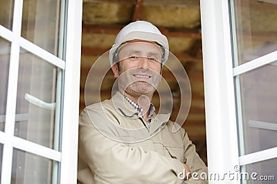 construction worker stood at open windows Stock Photo