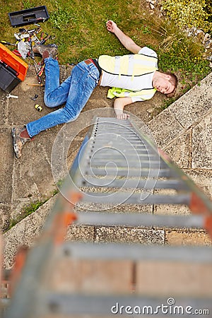 Construction Worker Suffering Injury After Fall From Ladder Stock Photo