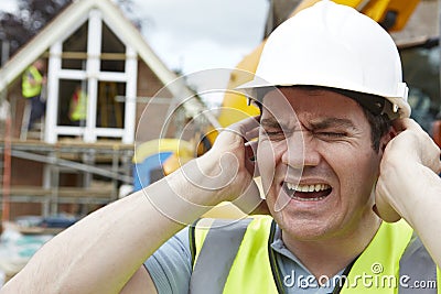 Construction Worker Suffering From Noise Pollution On Building Site Stock Photo