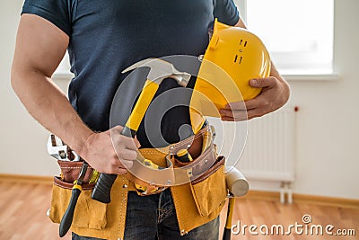 Construction worker with tool belt and hammer Stock Photo