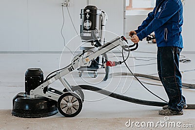 Construction worker using machine polishing surface floor smoothing and finishing hardener or epoxy concrete in the factory Stock Photo