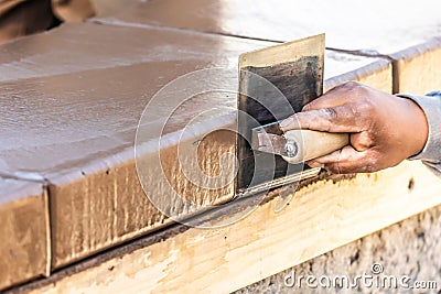 Construction Worker Using Stainless Steel Edger On Wet Cement Forming Coping Around New Pool Stock Photo