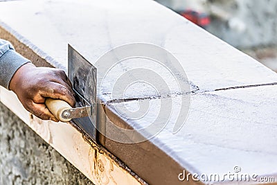 Construction Worker Using Stainless Steel Edger On Wet Cement Forming Coping Around New Pool Stock Photo