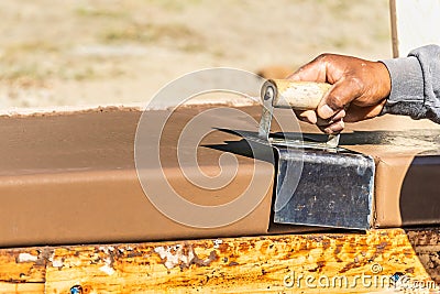 Construction Worker Using Stainless Steel Edger On Wet Cement Forming Coping Around New Pool Stock Photo