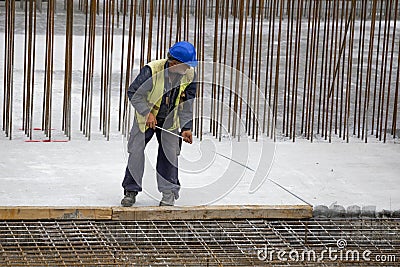 Construction worker using tape measure Editorial Stock Photo