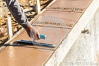 Laborer Using Trowel On Wet Cement Forming Coping Around New Pool Stock Photo