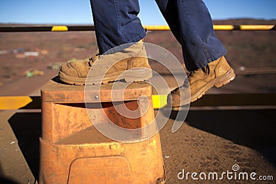 Construction worker wearing heavy duty steel cap boot using safety step white working at height Stock Photo