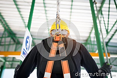 Construction worker wearing safety harness and safety line working at high place Stock Photo