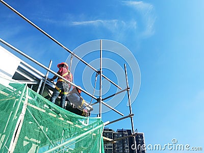 Construction workers install trusses and roofing sheets at construction sites. Editorial Stock Photo