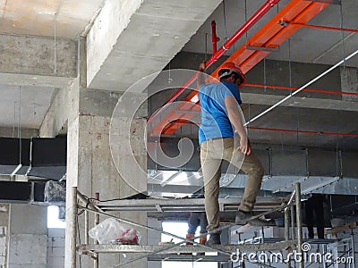 Construction workers installing electrical cable tray on the floor soffit. Editorial Stock Photo