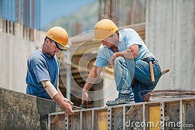 Construction workers installing formwork frames Stock Photo