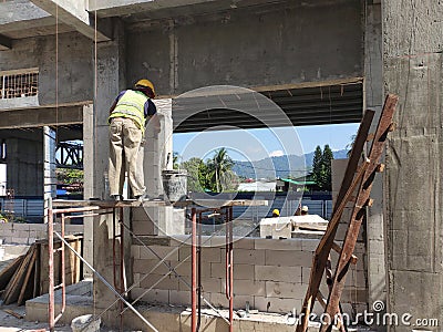 Construction workers laying autoclaved aerated concrete block at the construction site. Editorial Stock Photo