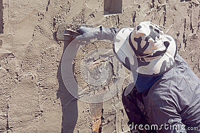 Construction workers plastering building wall using cement plaster Editorial Stock Photo